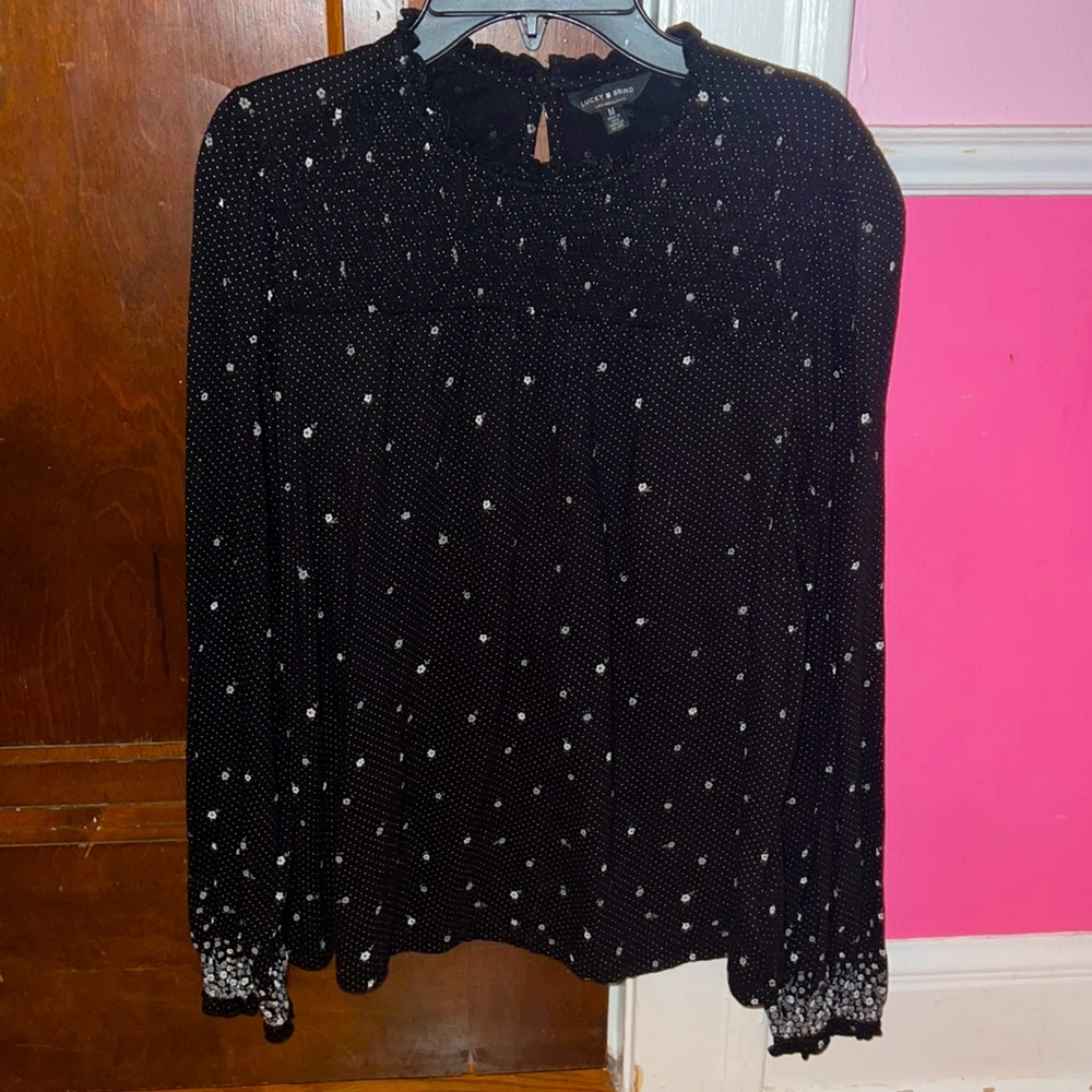 A black blouse with flowers and a ribbed top part.